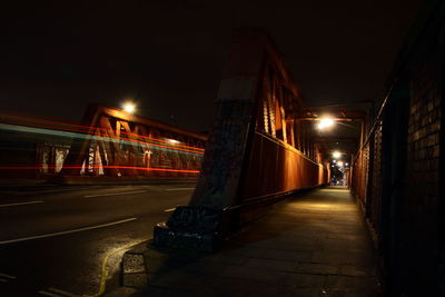 Illuminated bridge in city at night