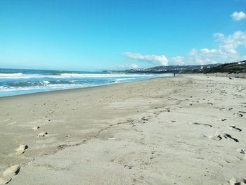 Scenic view of beach against blue sky