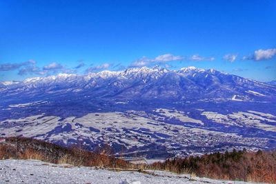 Scenic view of snowcapped mountains against blue sky