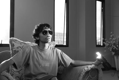 Portrait of man sitting on sofa at home