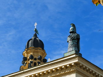 Low angle view of statue of building against blue sky