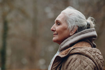 Portrait of a smiling young woman looking away outdoors