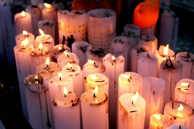 Close-up of lit candles on table at night