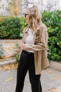 Young woman standing on footpath