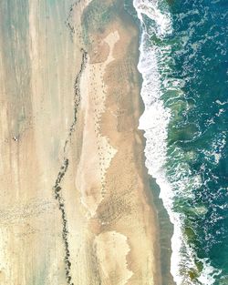 High angle view of waves rushing towards shore