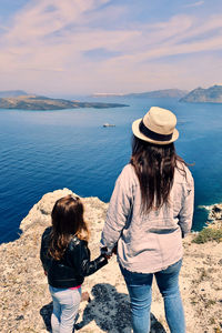 Side view of woman looking at sea against sky
