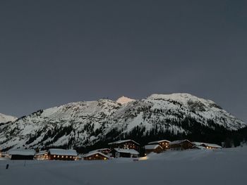 Houses on snowcapped mountains against sky