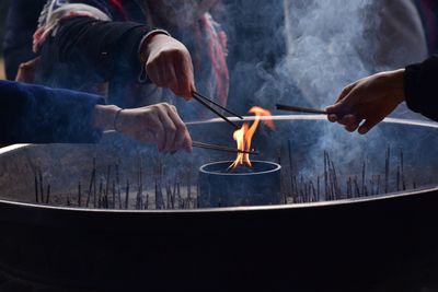 People burning incense sticks in temple