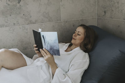 Woman on sofa reading book