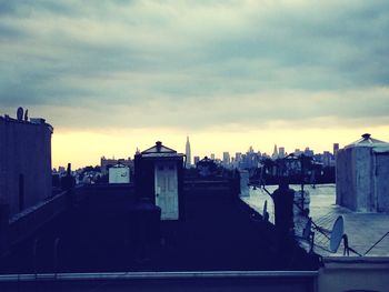 Buildings against cloudy sky at sunset