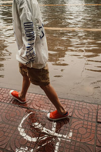 Low section of man walking on street