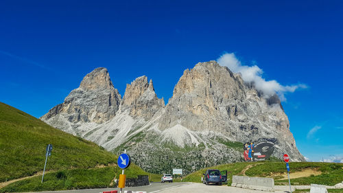 Panoramic view of land and mountains against blue sky