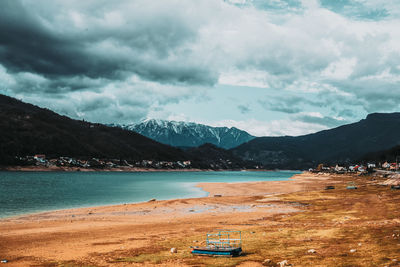 Scenic view of sea and mountains against sky