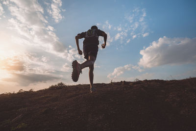 Low angle view of man skateboarding on field against sky