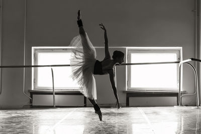 Full length of young ballet dancer balancing on floor