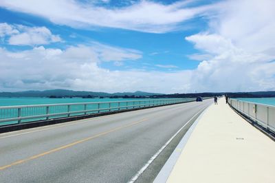 Bridge over river against cloudy sky