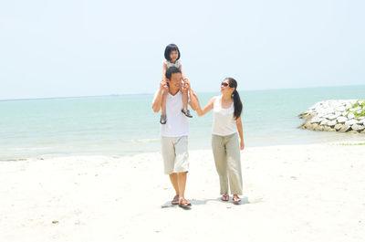 Woman standing on beach against clear sky