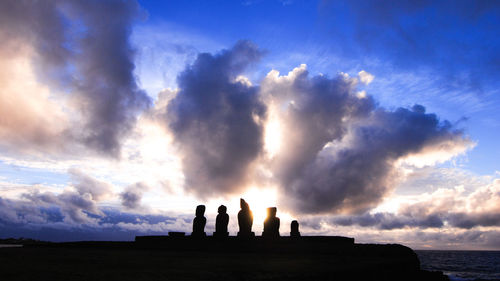 Silhouette people by sea against sky during sunset