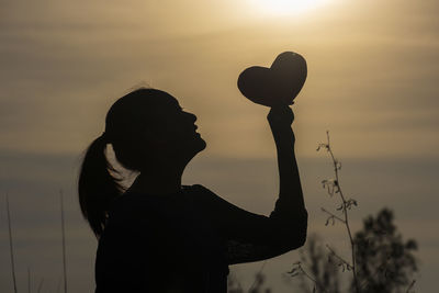 Portrait of silhouette woman standing against sky during sunset