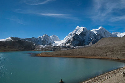 Scenic view of lake and snowcapped mountains against blue sky