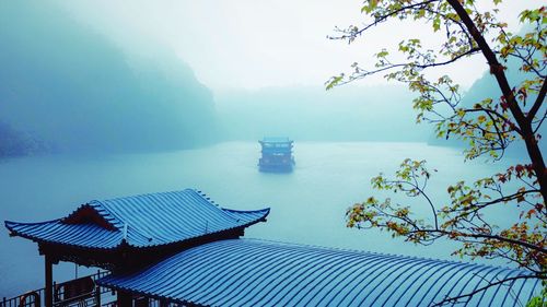 Scenic view of boat in calm sea through fog