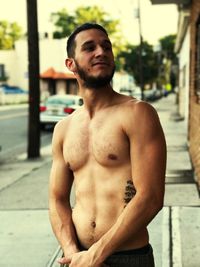 Young man looking away while standing outdoors