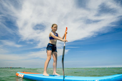 Full length of woman standing on sea against sky