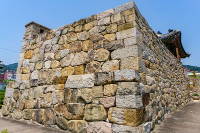 Low angle view of stone wall against sky