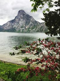 Scenic view of sea and mountains against cloudy sky