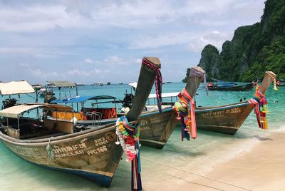 Boats moored on beach against sky