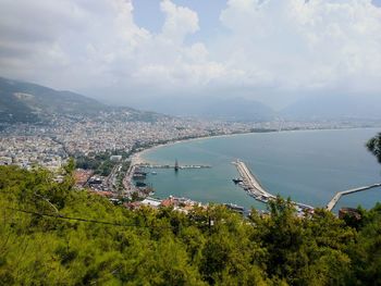 High angle view of cityscape by sea against sky