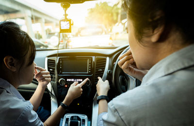 Rear view of friends sitting in car