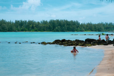 Man swimming in sea against sky