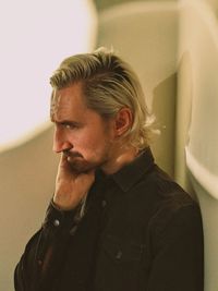 Portrait of young man looking away at home