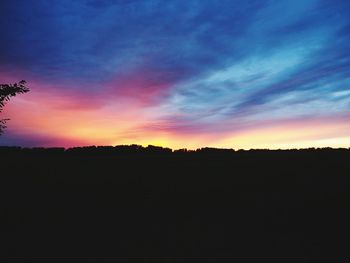 Silhouette landscape against dramatic sky during sunset