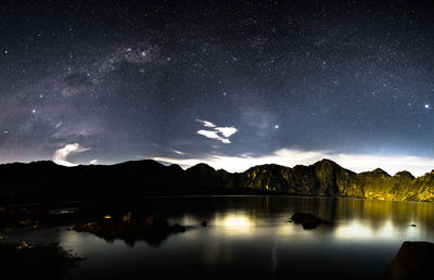 Scenic view of lake against sky at night