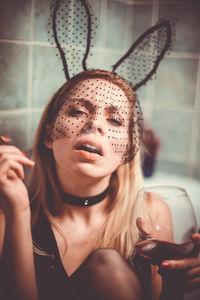 Portrait of young woman holding ice cream at home