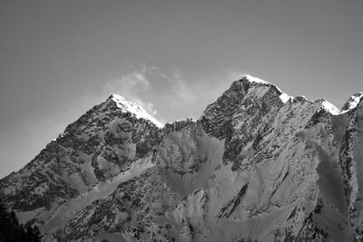 Low angle view of snowcapped mountains against clear sky