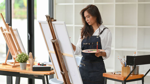 Woman looking away while standing on table