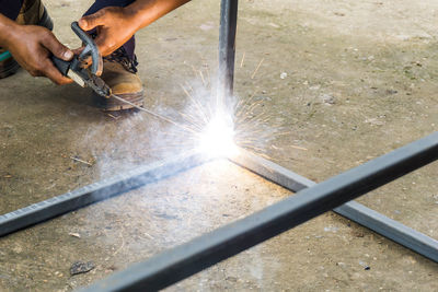 Cropped image of manual worker using machinery while working at factory