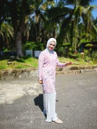 Full length of woman standing by tree