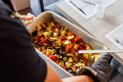 High angle view of person holding food on table