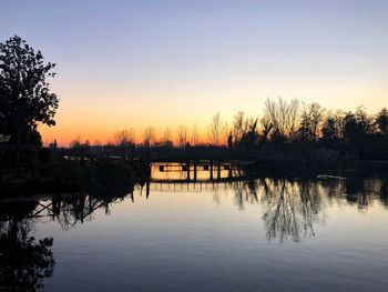 Scenic view of lake against clear sky during sunset