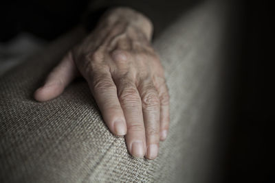 Close-up of person hand on armrest