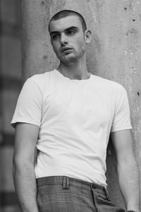 Young man looking away against wall