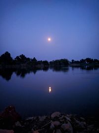 Scenic view of lake against sky at night