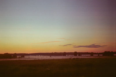 Scenic view of field against sky at sunset