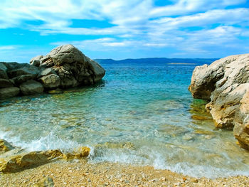 Rock formation in sea against sky