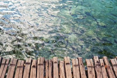 High angle view of wooden fence by lake