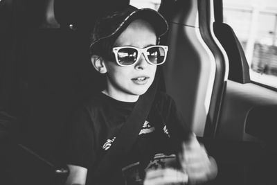 Portrait of boy wearing sunglasses in car
